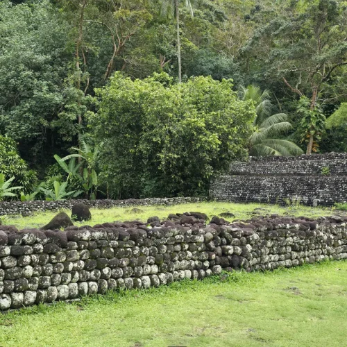 Marae Arahurahu à Tahiti avec murs en pierre volcanique entourés de végétation tropicale