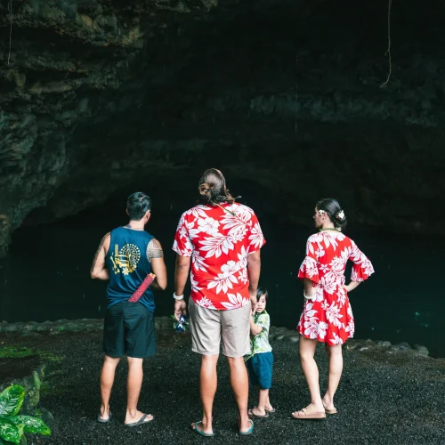 Famille devant le bassin sombre de la grotte de Maraa à Tahiti